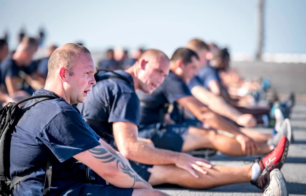 sailors perform stretches on ship